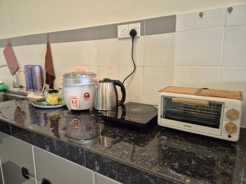 a kitchen counter with a toaster and a microwave at 4-10pax BAYU BEACH 2R2B PRIVATE BEACH, WATERSPORT, Pool, Bbq, Wifi, 50"TV in Port Dickson