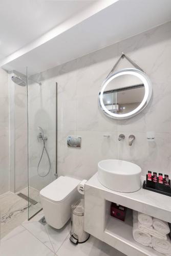a white bathroom with a sink and a mirror at Evdokia Artheon in Rhodes Town