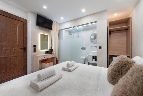 a bedroom with a white bed with towels on it at Evdokia Artheon in Rhodes Town