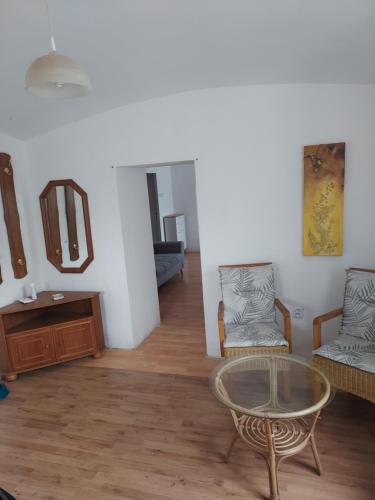 a living room with a glass table and chairs at Apartmán v okresu Děčin 