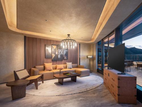 a living room with a couch and a tv at Aden Hotel Shenzhen Nanshan in Shenzhen