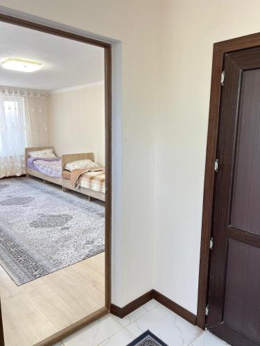 a mirror reflection of a bedroom with a bed at Tunduk Guest House in Kochkor