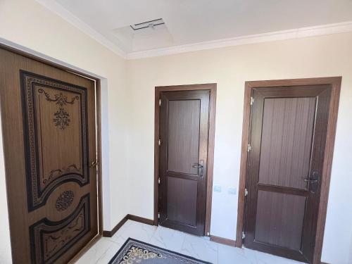 two wooden doors in a room with a rug at Tunduk Guest House in Kochkor