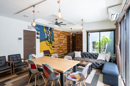 a living room with a wooden table and chairs at Cyclo Villa - JUNGLIA15分! 美ら海25分! ビーチ古宇利島すぐ! BBQ無料貸出! in Nago