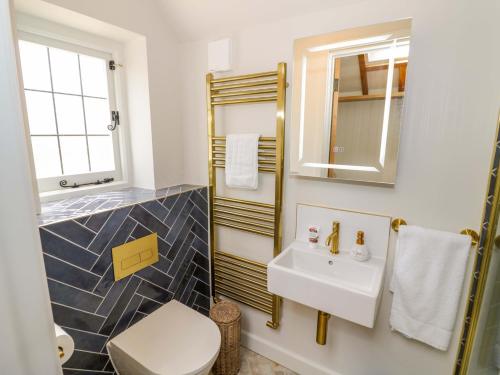 a bathroom with a sink and a toilet and a mirror at Wyncliffe in Chipping Campden