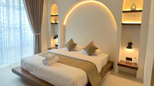 a bedroom with two beds and a large window at Malasama Suites Hotel in Kuta Lombok