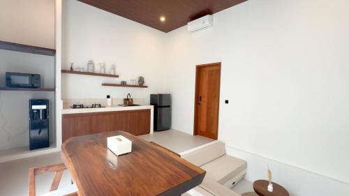 a living room with a table and a kitchen at Malasama Suites Hotel in Kuta Lombok