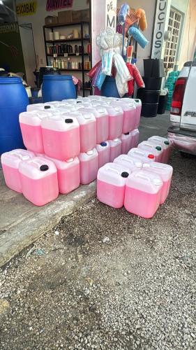 a group of pink containers sitting on the ground at Cáliz 1 in Emiliano Zapata
