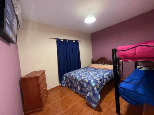 a bedroom with a bunk bed and a blue curtain at Casa Tomas 2 in Villa Unión