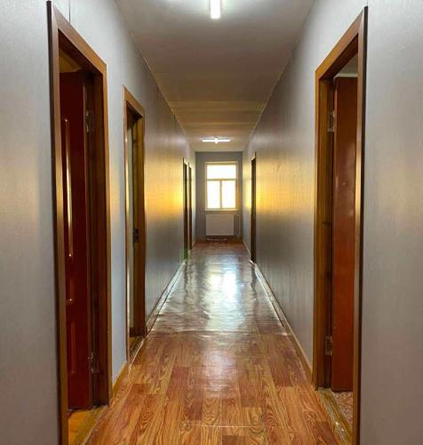 an empty hallway with wooden floors and doors at 247 hotel in Ulaanbaatar