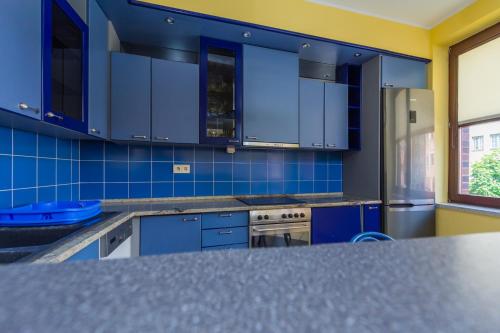 a kitchen with blue cabinets and a counter top at Apartament Stare Miasto 2 in Elblag