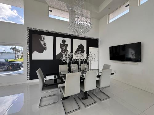 a dining room with a black table and white chairs at The Monochrome Villa in Fort Lauderdale