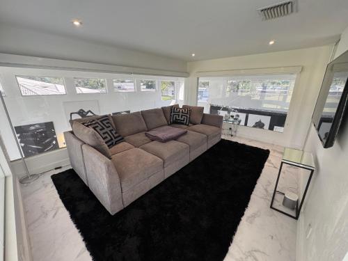 a living room with a brown couch in a room with windows at The Monochrome Villa in Fort Lauderdale