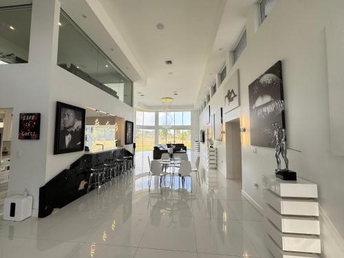 a hallway with a dining room with tables and chairs at The Monochrome Villa in Fort Lauderdale