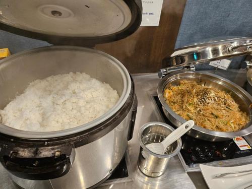 a counter with two pots of rice on a stove at With Stay Jeju Hotel in Jeju
