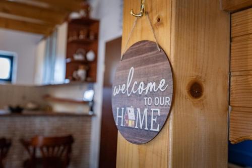 a wooden door with a sign that reads welcome to our home at Guest house Holiday in Žabljak