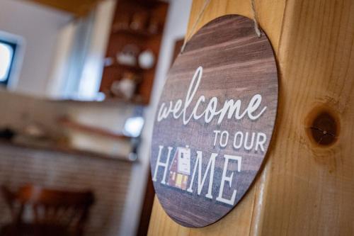 a wooden door with a welcome to our home sign at Guest house Holiday in Žabljak