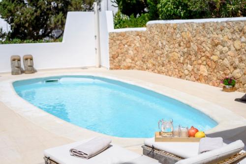 a large swimming pool with a stone wall at Casa Zita Mar 6p beach villa 5min walk in Cala Llonga