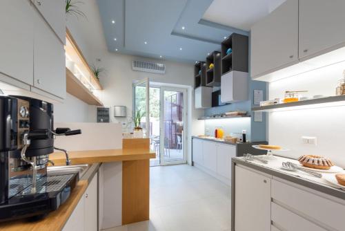 a kitchen with white cabinets and a coffee maker at Dolcirive B&B - Porto Cesareo in Porto Cesareo