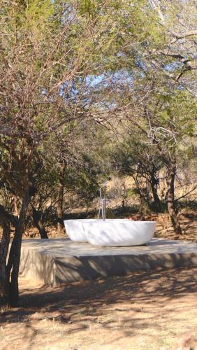 a bath tub sitting on top of a concrete slab at Mologa River Lodge in Rust de Winter