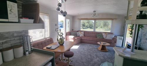 a living room with a couch and a table at ML23 8 BERTH CARAVAN GOLDEN PALM CHAPEL ST LEONARDS in Chapel Saint Leonards
