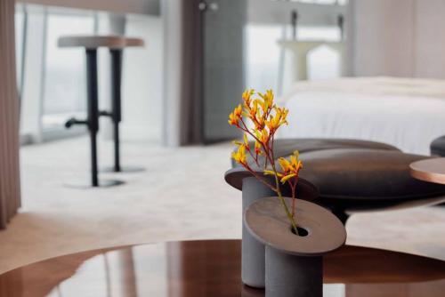 a chair with a flower on a table in a room at Vilnius TV Tower Apartments DEBESYS in Vilnius