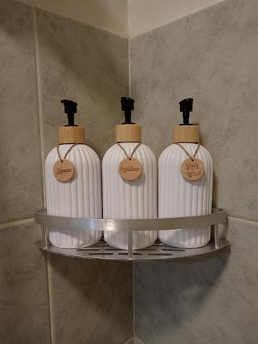 three white bottles on a shelf in a bathroom at Sweet Escape 305 at Amaia Steps in Bacolod
