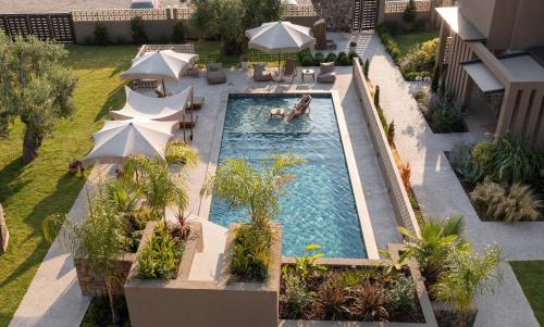 an overhead view of a swimming pool with umbrellas at Pournari Mountain Rooms in Toroni