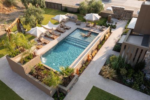 an overhead view of a swimming pool with chairs and umbrellas at Pournari Mountain Rooms in Toroni