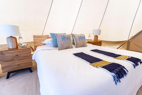 a bedroom with a large white bed and a wooden dresser at The MAVERICK SURF AND DIVE BOUTIQUE HOTEL - Book 10 Nights and get 1 Free Night - Free Speed Boat Service - Kids Stay Free in Laamu