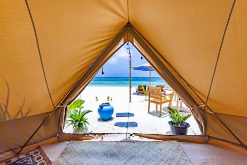 a tent with a view of the beach from the inside at The MAVERICK SURF AND DIVE BOUTIQUE HOTEL - Book 10 Nights and get 1 Free Night - Free Speed Boat Service - Kids Stay Free in Laamu