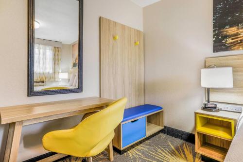 a room with a desk and a yellow chair at Days Inn by Wyndham Cortez in Cortez