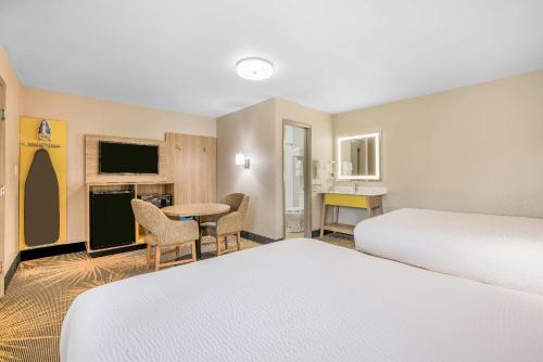 a hotel room with two beds and a table at Days Inn by Wyndham Cortez in Cortez