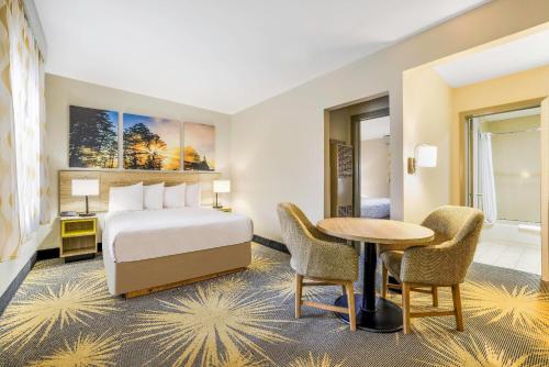 a hotel room with a bed and a table and chairs at Days Inn by Wyndham Cortez in Cortez