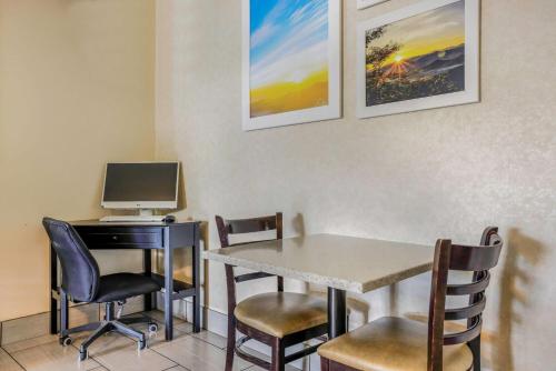 a room with a desk with a computer and chairs at Days Inn by Wyndham Cortez in Cortez
