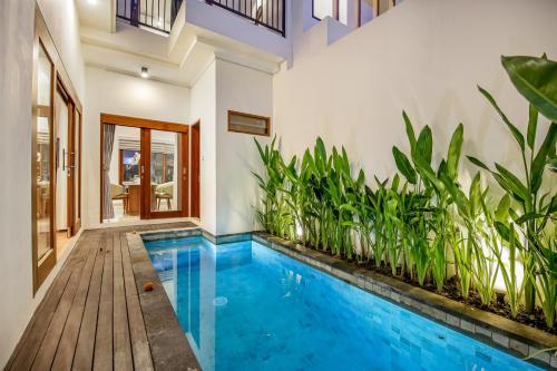 an indoor pool in a house with plants at Ellavie Villa Nusa Dua in Nusa Dua