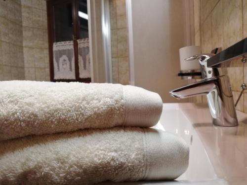 a pile of towels sitting on a bathroom sink at Ansitz Grustdorf in Appiano sulla Strada del Vino