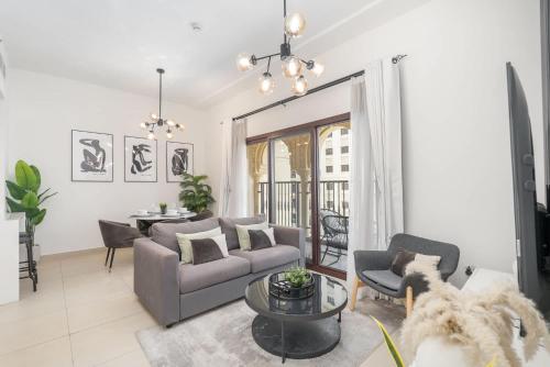 a living room with a couch and a table at Free housekeeping visits during your stay - StayShort - Stylish 1-Bedroom Retreat with Pool in Vibrant Jumeirah Golf Estates in Dubai