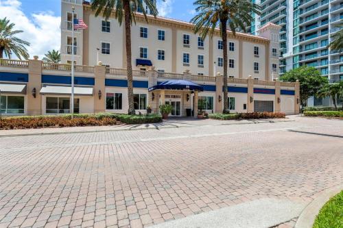 a large building with palm trees in front of it at Hampton Inn & Suites St. Petersburg/Downtown in St. Petersburg