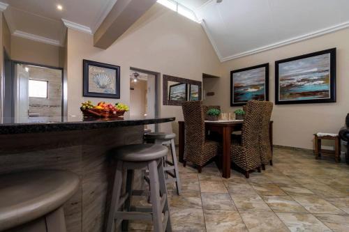 a bar in a room with a table and chairs at Pink Maraboi Resort in Kisumu