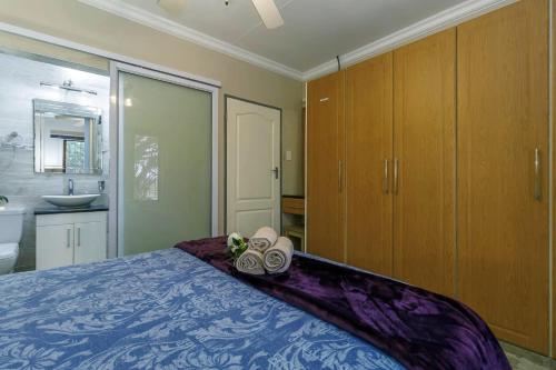 a bedroom with a bed with towels and a sink at Pink Maraboi Resort in Kisumu