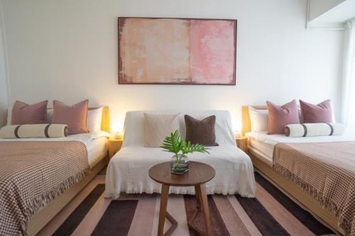 a living room with two beds and a table at 樂居 台北 in T'ung-ko