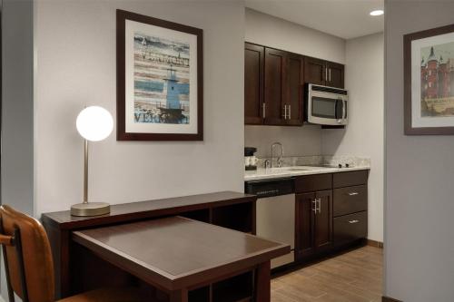 a kitchen with a table and a microwave at Homewood Suites by Hilton Burlington in Burlington