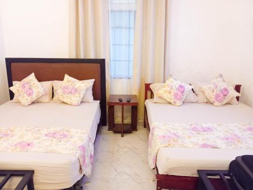 a room with two beds with pillows at Fern Hill Cottage Kandy in Kandy