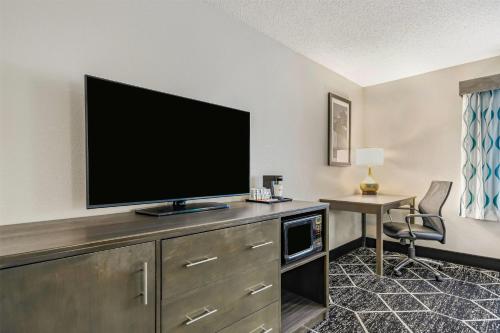 a hotel room with a flat screen tv on a cabinet at La Quinta by Wyndham Batavia in Batavia