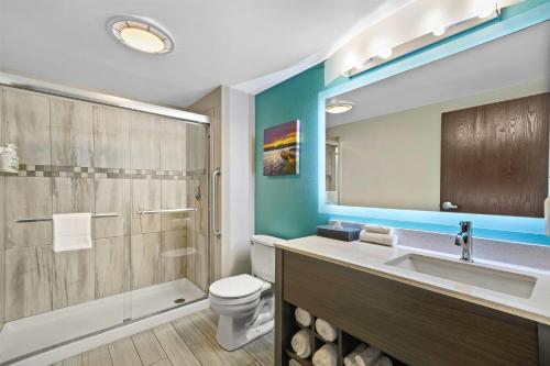 a bathroom with a sink and a toilet and a mirror at La Quinta by Wyndham Batavia in Batavia
