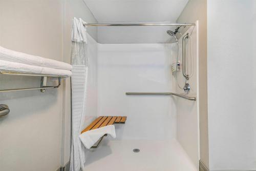 a white bathroom with a shower and a toilet at La Quinta by Wyndham Batavia in Batavia