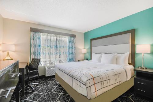 a hotel room with a bed and a window at La Quinta by Wyndham Batavia in Batavia