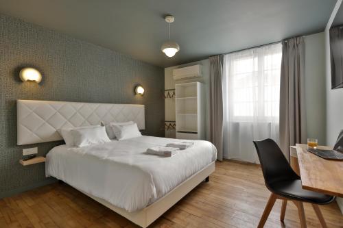 a bedroom with a large white bed and a desk at Le Chic & Raffiné - Terrasse & Climatisé in Périgueux