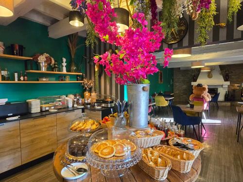 a table with baskets of food and a vase with flowers at Hôtel Le SAINT-GENIÈS in Uzès